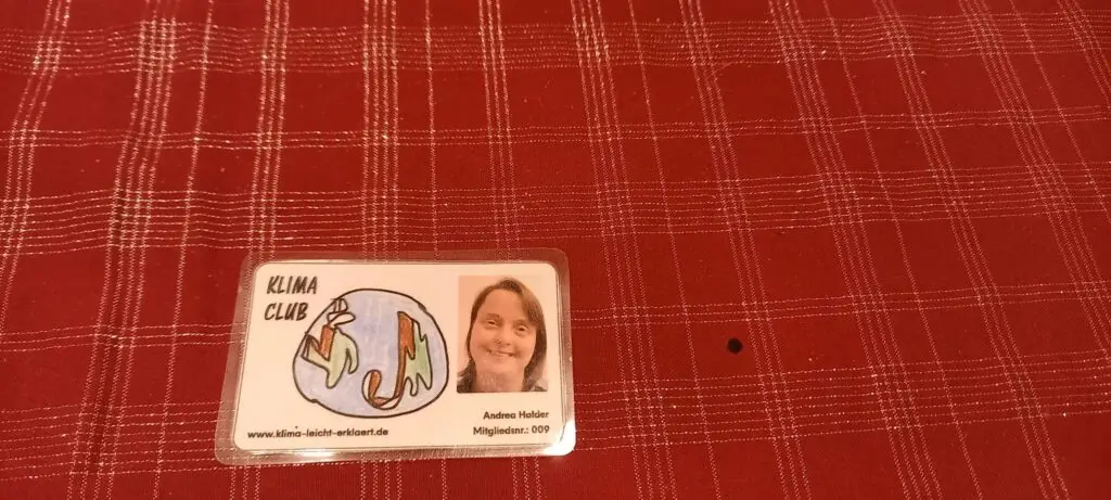 Eine rötliche Decke als Untergrund, darauf liegt der Klima Club Ausweis von Andrea Halder